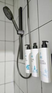 a group of three bottles of soap in a shower at Alpin Motel & Conference Centre in Rotorua