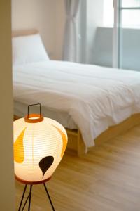 a bedroom with a bed with a lamp next to it at Bou house in Tainan