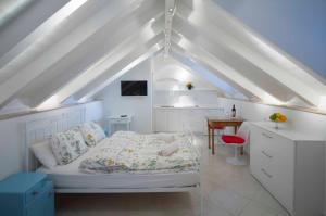 ドゥブロヴニクにあるテンプラー レジデンス アパートメンツのベッドと机のある白い寝室