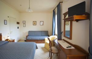 a bedroom with a bed and a desk with a mirror at Albergo Stella in Casciana Terme