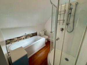a bathroom with a bath tub and a toilet at 25 Leamington Street in Hanmer Springs +14 photos