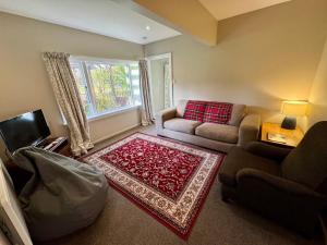 a living room with a couch and a chair at 25 Leamington Street in Hanmer Springs