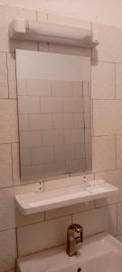 a bathroom with a mirror and a sink at Maleh Plus in Kribi +1 photo