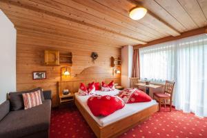 Un dormitorio con una cama con almohadas rojas. en Gästehaus Alpenblick, en Berwang