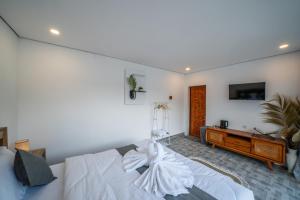 a bedroom with a white bed and a desk at Heaven House Kintamani in Kubupenlokan