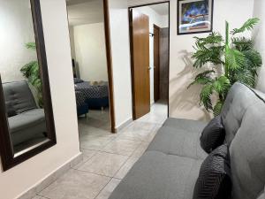 ein Wohnzimmer mit einer Couch und einem Spiegel in der Unterkunft blue angel 4 in Playa del Carmen