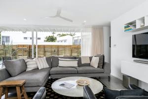 a living room with a couch and a table at Sanctuary Spaces - Lomani Six in Byron Bay