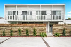 a house with a wooden fence in front of it at Sanctuary Spaces - Lomani Six in Byron Bay
