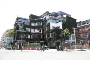a building covered in ivy on a city street at Hotel Marcopolo in Kathmandu