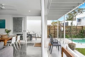 a living room and dining room with a table and chairs at Sanctuary Spaces - Lomani Six in Byron Bay