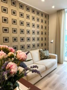 a living room with a couch and a table with flowers at Sul Corso Sanremo in Sanremo