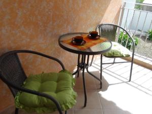 stół z dwoma krzesłami i dwoma kubkami na nim w obiekcie la rosa bianca w mieście Fluminimaggiore