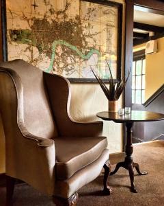a chair and a table in a room with a map at The Crown Inn in Chiddingfold