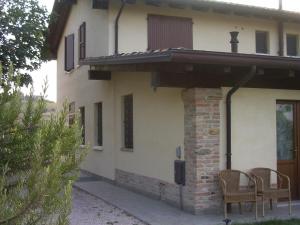 a house with a table and chairs in front of it at Agriturismo Macìn in Cesena