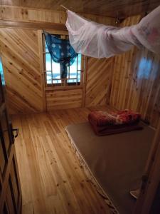 an inside view of a wooden room with a bed and a window at Zuzu Homestay in Sa Pa