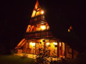 a lit up house with a tower at night at Holiday Home Tirol in Vlasic