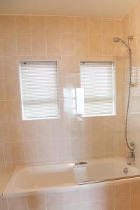 a bathroom with a bath tub and two windows at Diaz Beach Apartment in Diasstrand