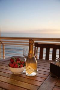 uma garrafa de champanhe e uma taça de morangos numa mesa em Diaz Beach Apartment em Diasstrand