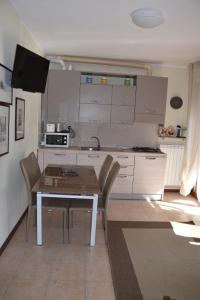 a kitchen with a table and chairs in a room at 4-persoonsappartement met terras aan het Comomeer in Acquaseria +10 photos