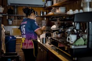 a woman standing in a kitchen preparing food at 15 Palms Beach Resort in Ko Chang