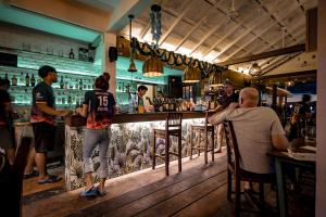 a group of people sitting at a bar at 15 Palms Beach Resort in Ko Chang