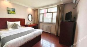 a bedroom with a bed and a television in it at GreenTree Inn Urumqi South Xinhua Road Hotel in Ürümqi