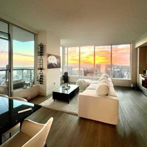 Una sala de estar con un sofá blanco y grandes ventanales. en Penthouse High-Rise Ocean & City Views, en San Diego 18 fotos más