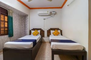 two twin beds in a room at SPOT ON Balaji Residency near Yeshwantupur Railway Station in Bengaluru