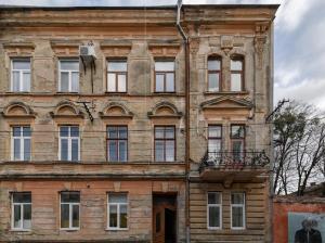 un viejo edificio de ladrillo con muchas ventanas en Вавілова апартаменти резиденція університету, en Chernivtsi