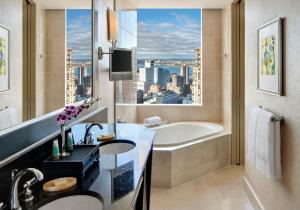 a bathroom with a large window and a large bathtub at Mandarin Oriental New York in New York