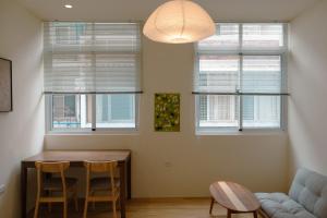 a living room with a table and two windows at Bou house in Tainan