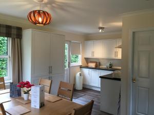 a kitchen with white cabinets and a wooden table at Bruce's Cottage in Stirling