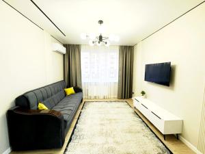 a living room with a couch and a tv at Марина 6 in Zhezdi