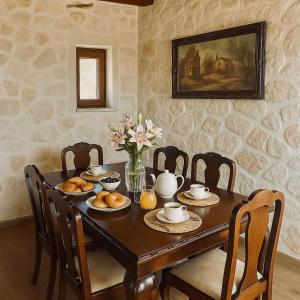 einen Esstisch mit Essen und Blumen darauf in der Unterkunft La Casa Del Sole in Agios Leon