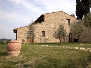 a stone house with a large vase in front of it at Casale Rosanna in San Gimignano