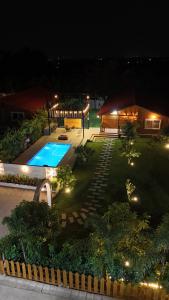 a backyard with a swimming pool at night at AVY Abode - 3bhk Farm Stay, Private Pool in Moinabad in Venkatāpur