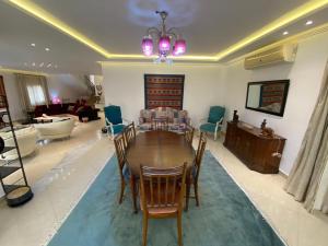 un salon avec une table et des chaises en bois dans l'établissement فيلا منفصله بحمام سباحه فى مدينتى, à Madinaty