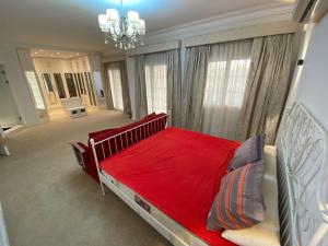 - une chambre avec un lit rouge et un lustre dans l'établissement فيلا منفصله بحمام سباحه فى مدينتى, à Madinaty 19 autres photos