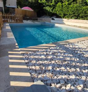 a swimming pool with a bunch of rocks around it at Bas de villa calme proche plages in La Seyne-sur-Mer