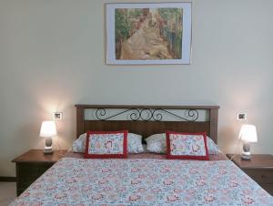 a bedroom with a bed with two lamps and a painting at CASA L'UNICORNO con giardino privato in Levanto