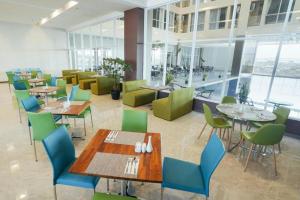 スラバヤにあるMy Tower Hotel Surabayaの建物内のダイニングルーム(テーブル、椅子付)