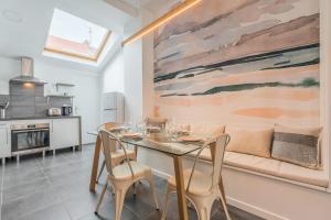 a dining room with a table and a couch at Maison 3 chambres, parking gratuit & proche métro in Croix