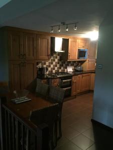 uma cozinha com armários de madeira, uma mesa e um fogão em Jackfield Mill Ironbridge Gorge em Telford