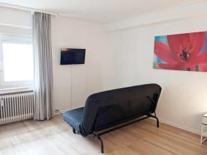 a black couch in a room with a painting on the wall at Work & Travel in Remscheid