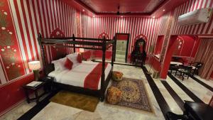 a bedroom with a canopy bed in a red room at RatanGarhi By Richa in Orchha