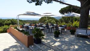 a restaurant with tables and chairs and umbrellas at Hôtel les Bouis - Vue mer in Saint-Tropez