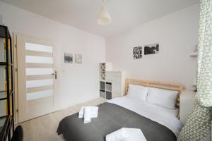 a bedroom with a bed with two towels on it at Bemowo Homely Apartment by BookingHost in Warszawa