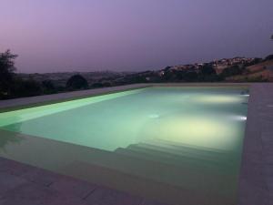 una piscina iluminada por la noche en Gastronomic B&B CarloCarla, en Monte San Pietrangeli