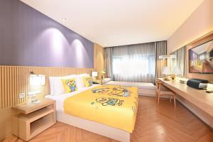 a hotel room with a large bed and a desk at Beijing Nanluoguxiang Orange Crystal Hotel in Beijing