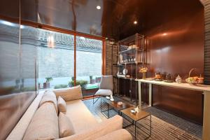 a living room with a couch and a counter at Beijing Nanluoguxiang Orange Crystal Hotel in Beijing